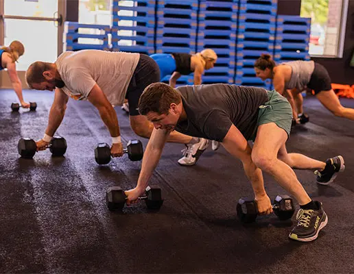 NLXF participants perform a weight workout holding dumbbells in each hand